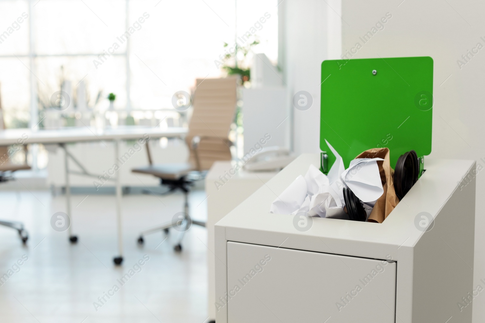 Photo of Open full trash bin in modern office, space for text. Waste recycling