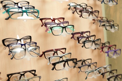 Photo of Showcase with different glasses in optical store. Ophthalmologist prescription