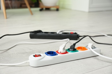 Extension cords on floor indoors, space for text. Electrician's professional equipment