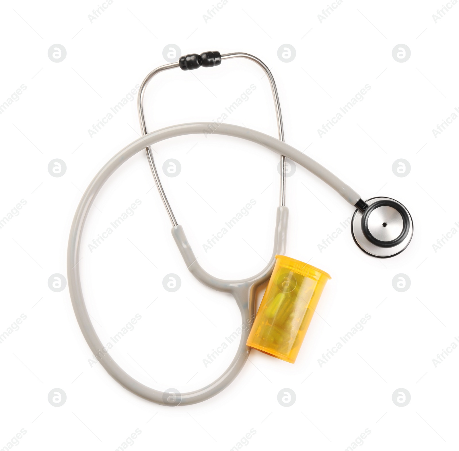 Photo of Stethoscope and container with pills isolated on white, top view. Medical tool