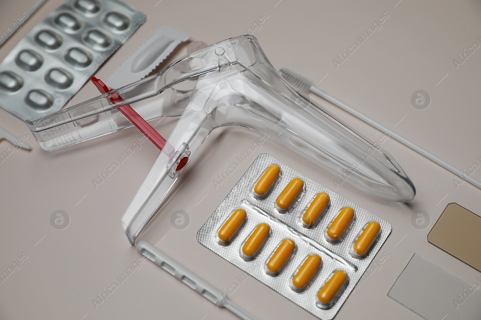 Photo of Sterile gynecological examination kit and medicaments on beige background
