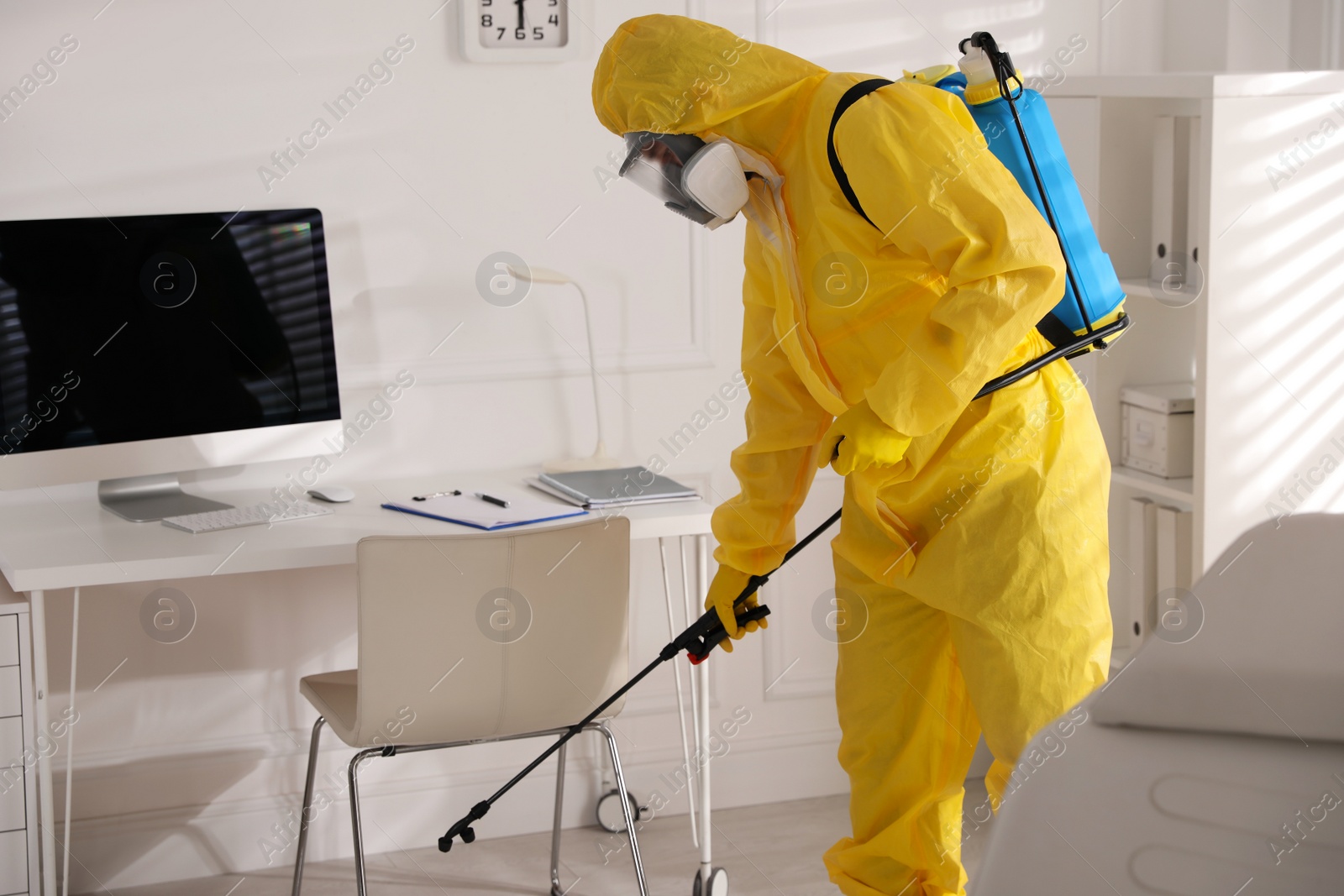 Photo of Man in protective suit sanitizing doctor's office. Medical disinfection