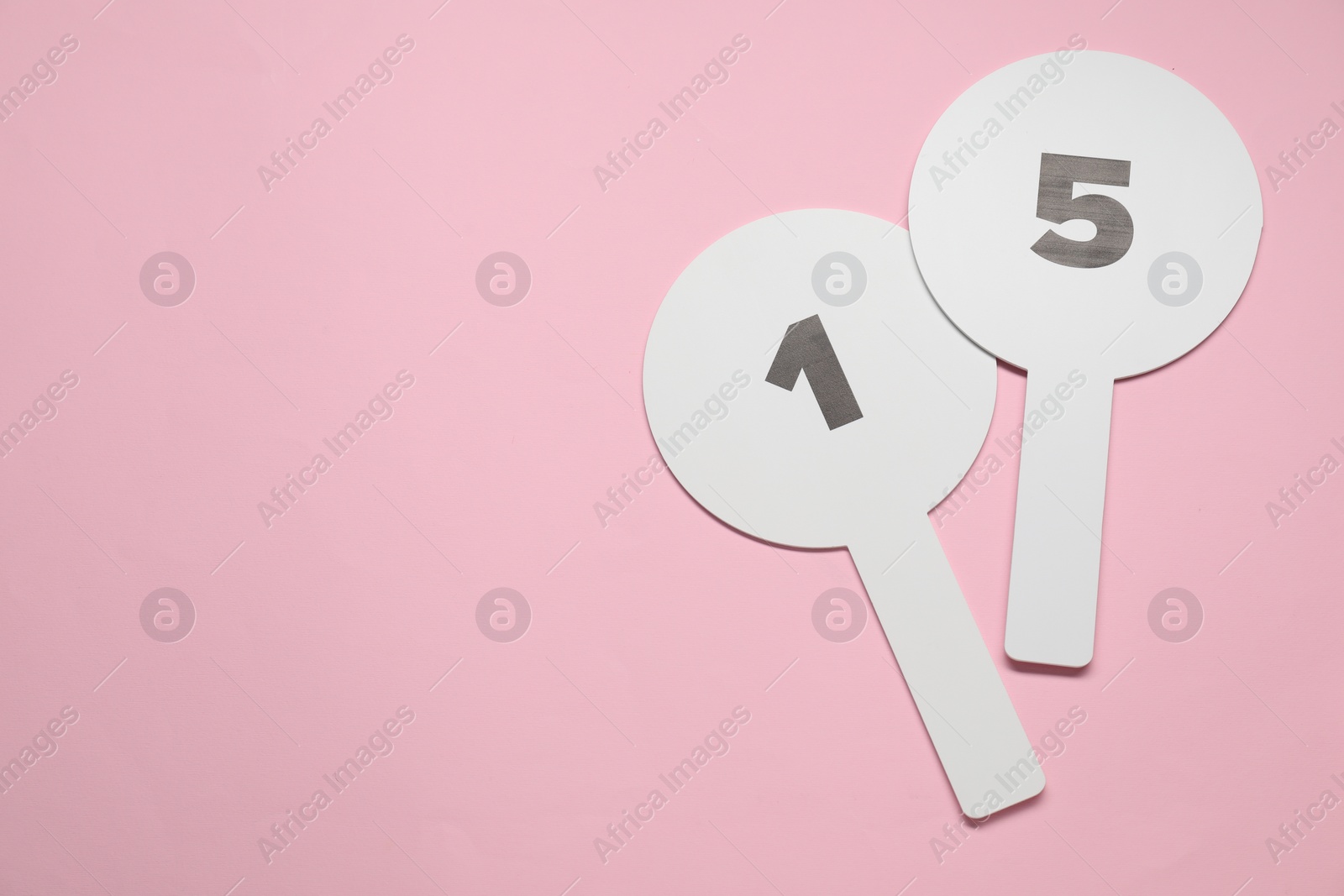 Photo of Auction paddles with numbers on pink background, top view. Space for text