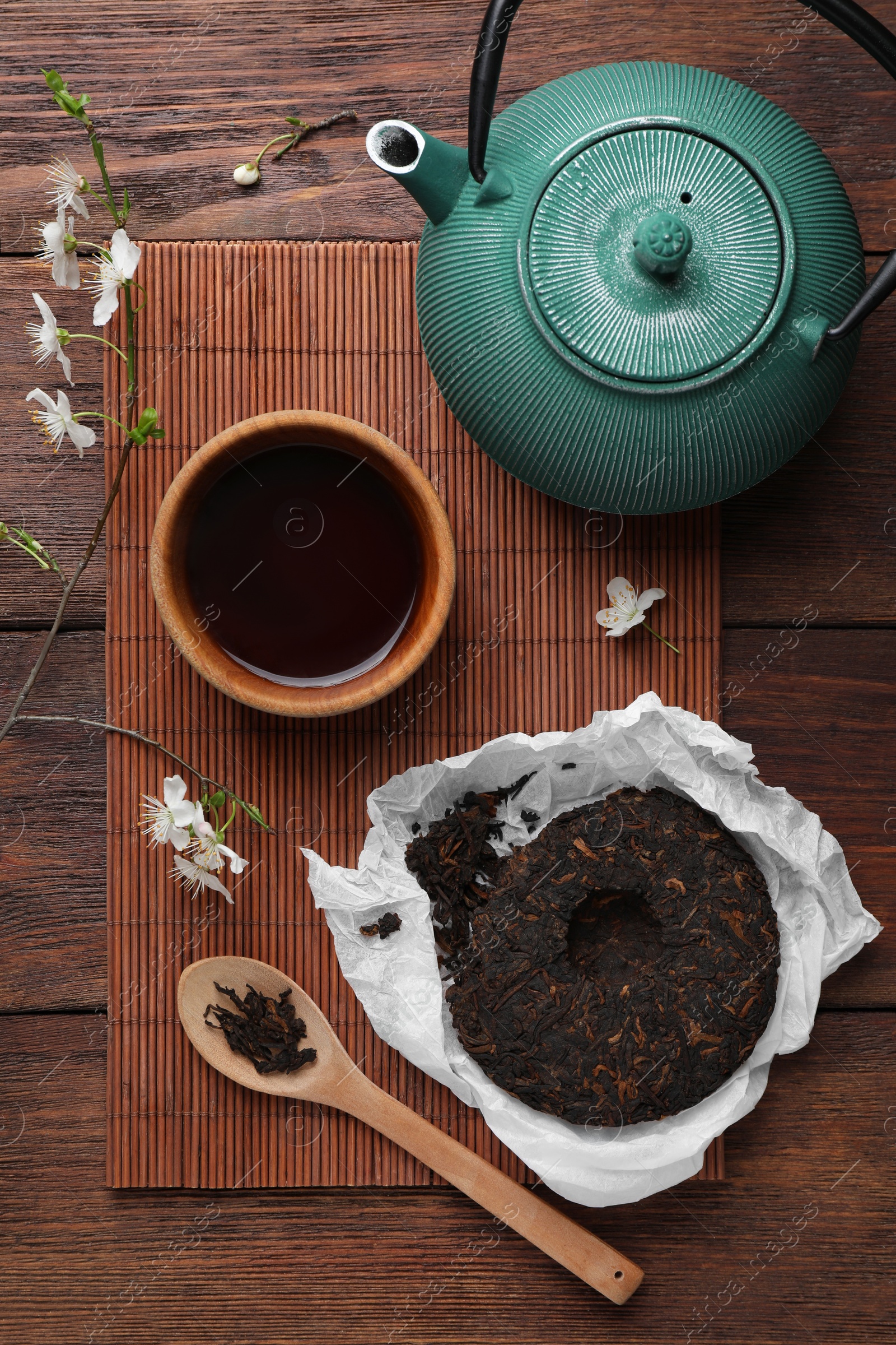 Photo of Flat lay composition with aromatic pu-erh tea on wooden table