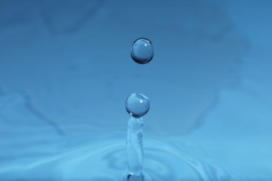 Photo of Splash of blue water with drop, macro view