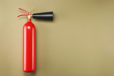 Photo of Fire extinguisher on light brown background, top view. Space for text
