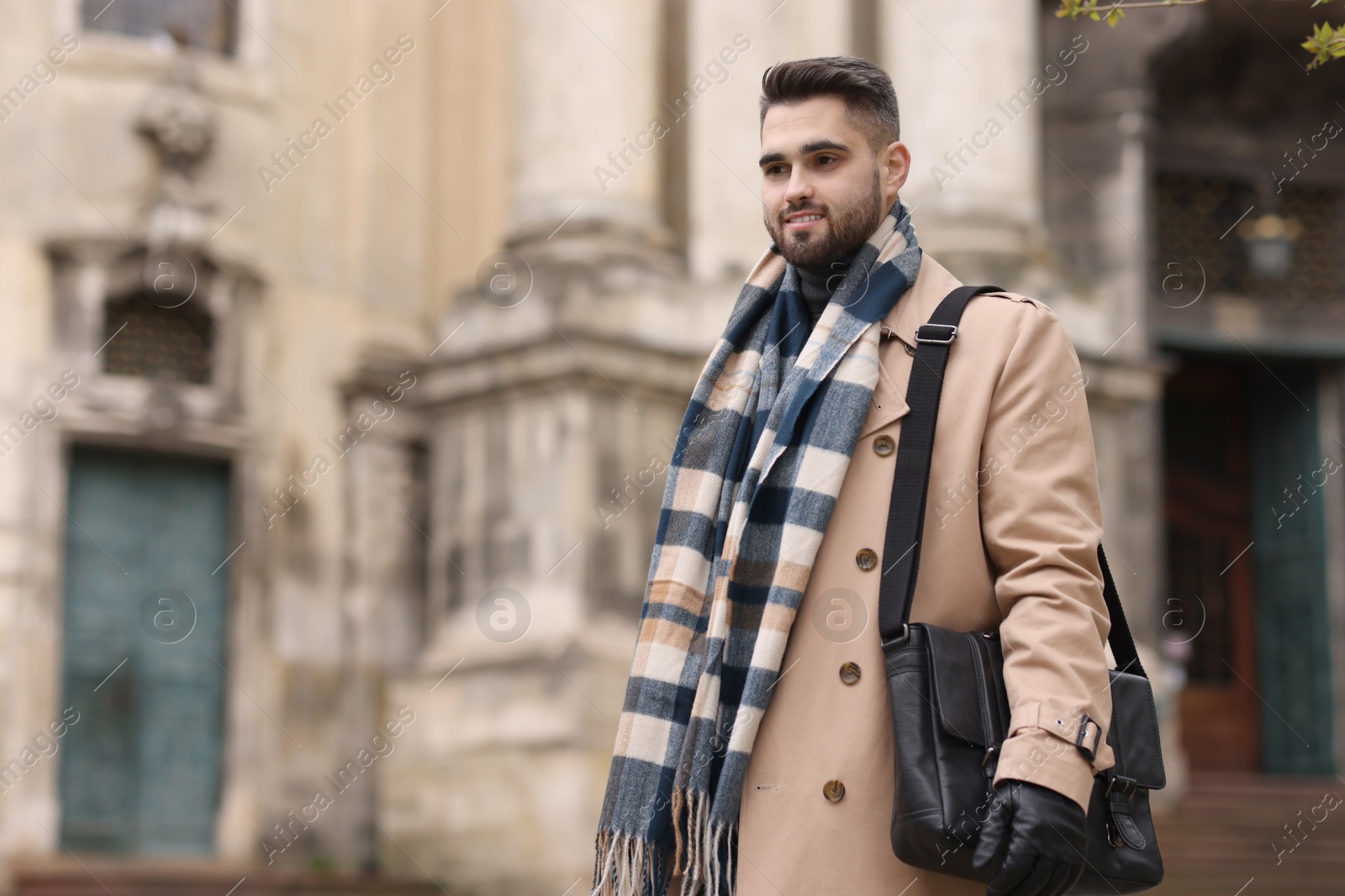 Photo of Smiling man in warm scarf outdoors. Space for text