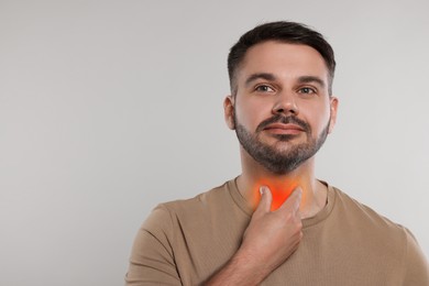 Endocrine system. Man doing thyroid self examination on light grey background, space for text