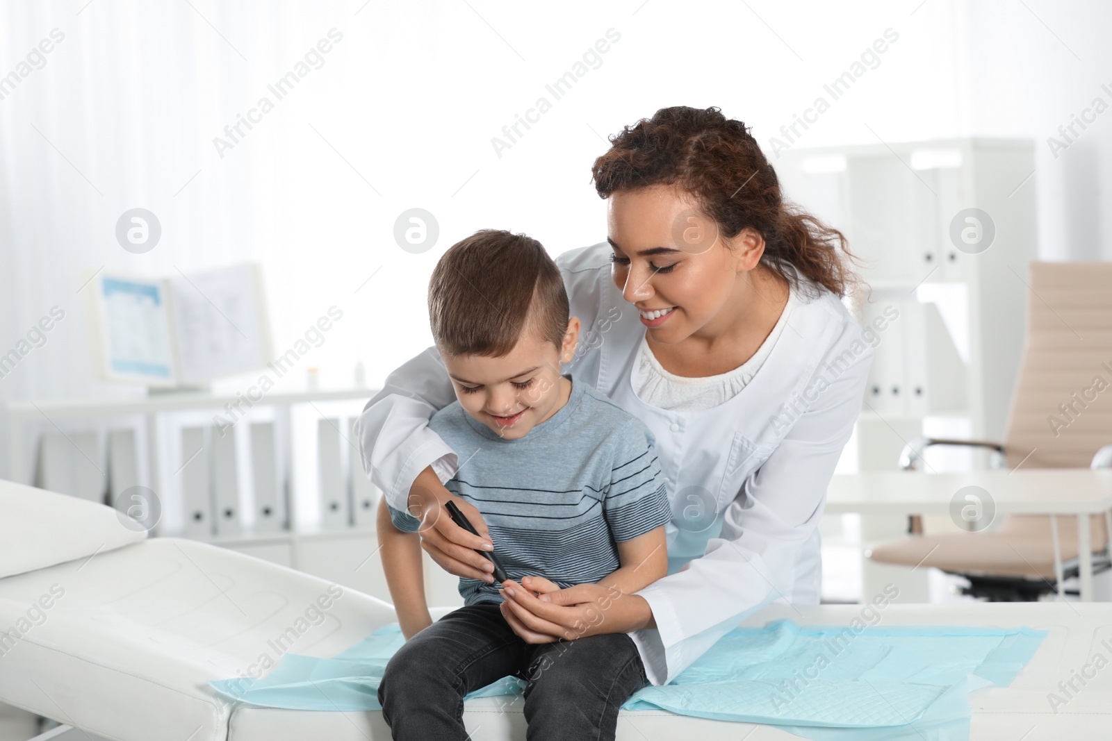 Photo of Doctor taking patient's blood sample with lancet pen in hospital. Diabetes control