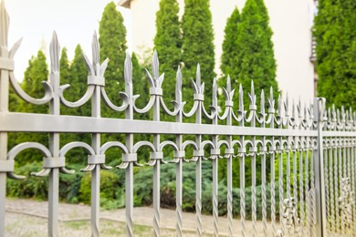 Photo of Trees behind beautiful iron fence near pathway outdoors