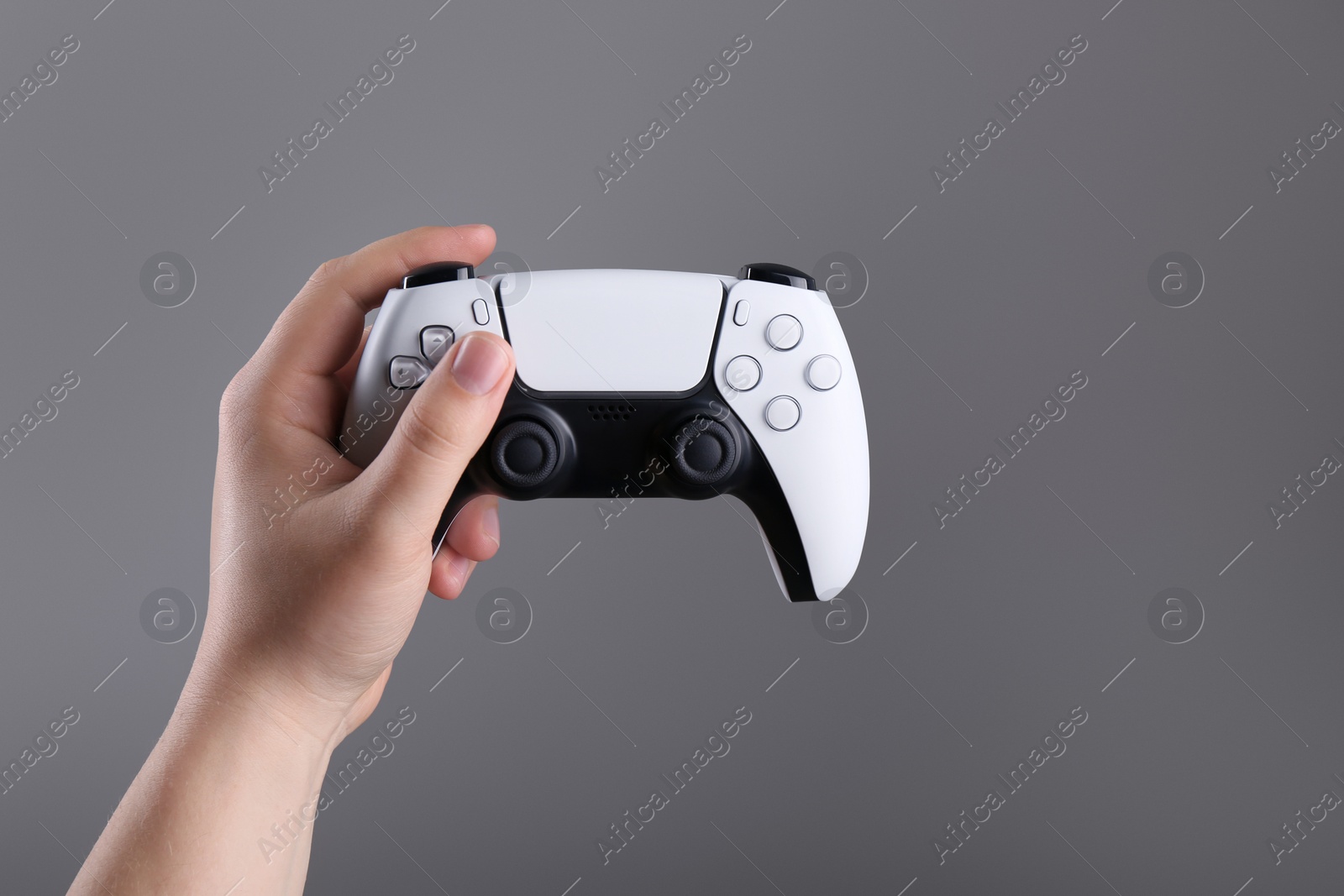 Photo of Woman using wireless game controller on grey background, closeup