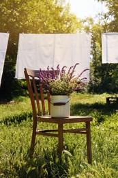 Photo of Beautiful bouquet with field flowers on chair outdoors