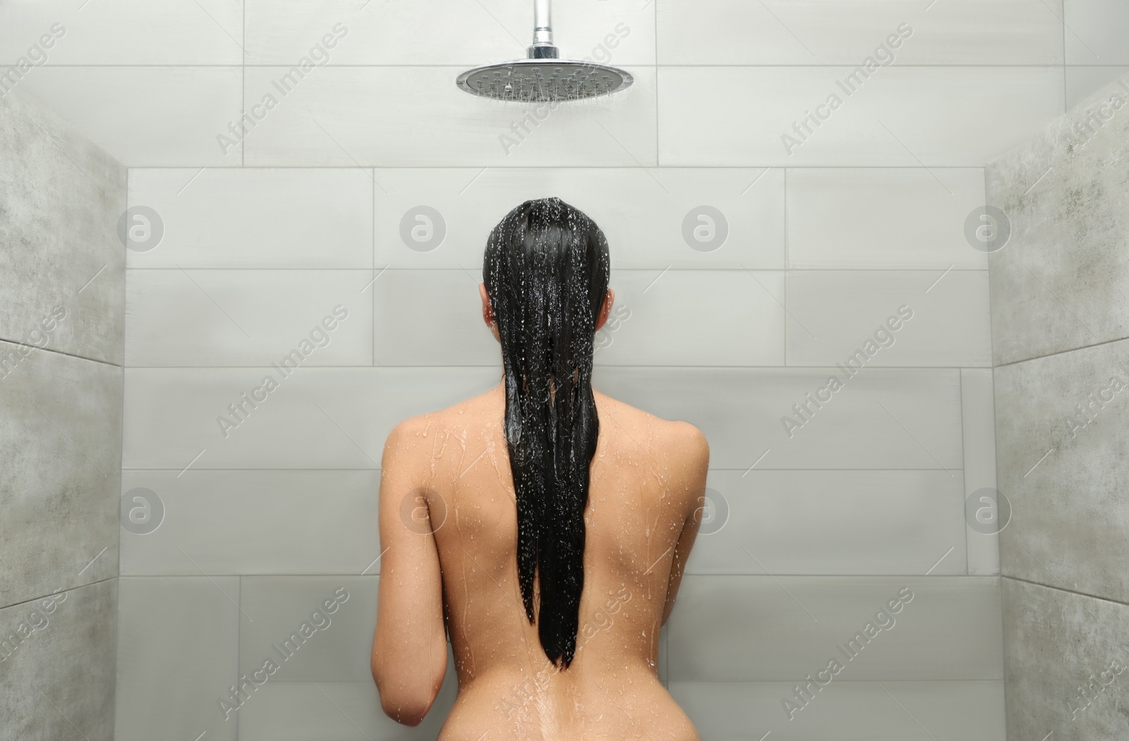 Photo of Beautiful young woman taking shower in spa center