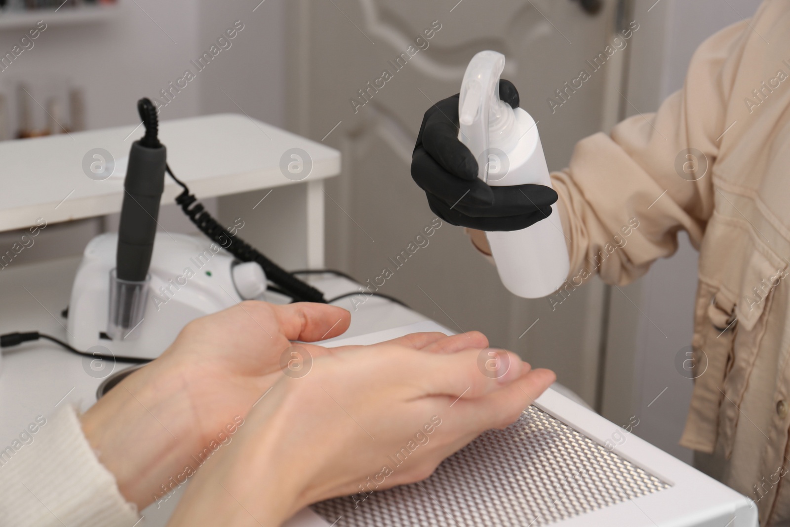 Photo of Professional manicurist working with client in salon, closeup