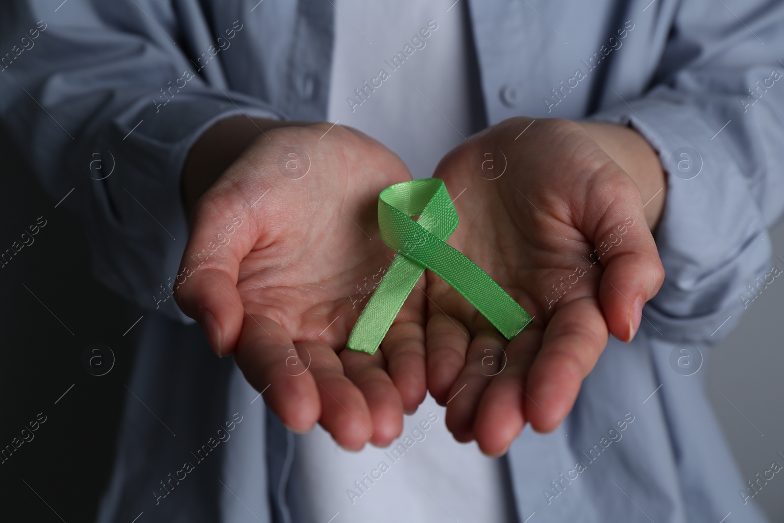 Photo of Woman with green awareness ribbon, closeup view