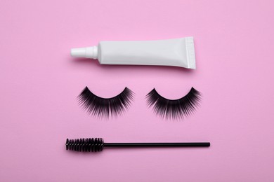 Photo of Flat lay composition with fake eyelashes on pink background