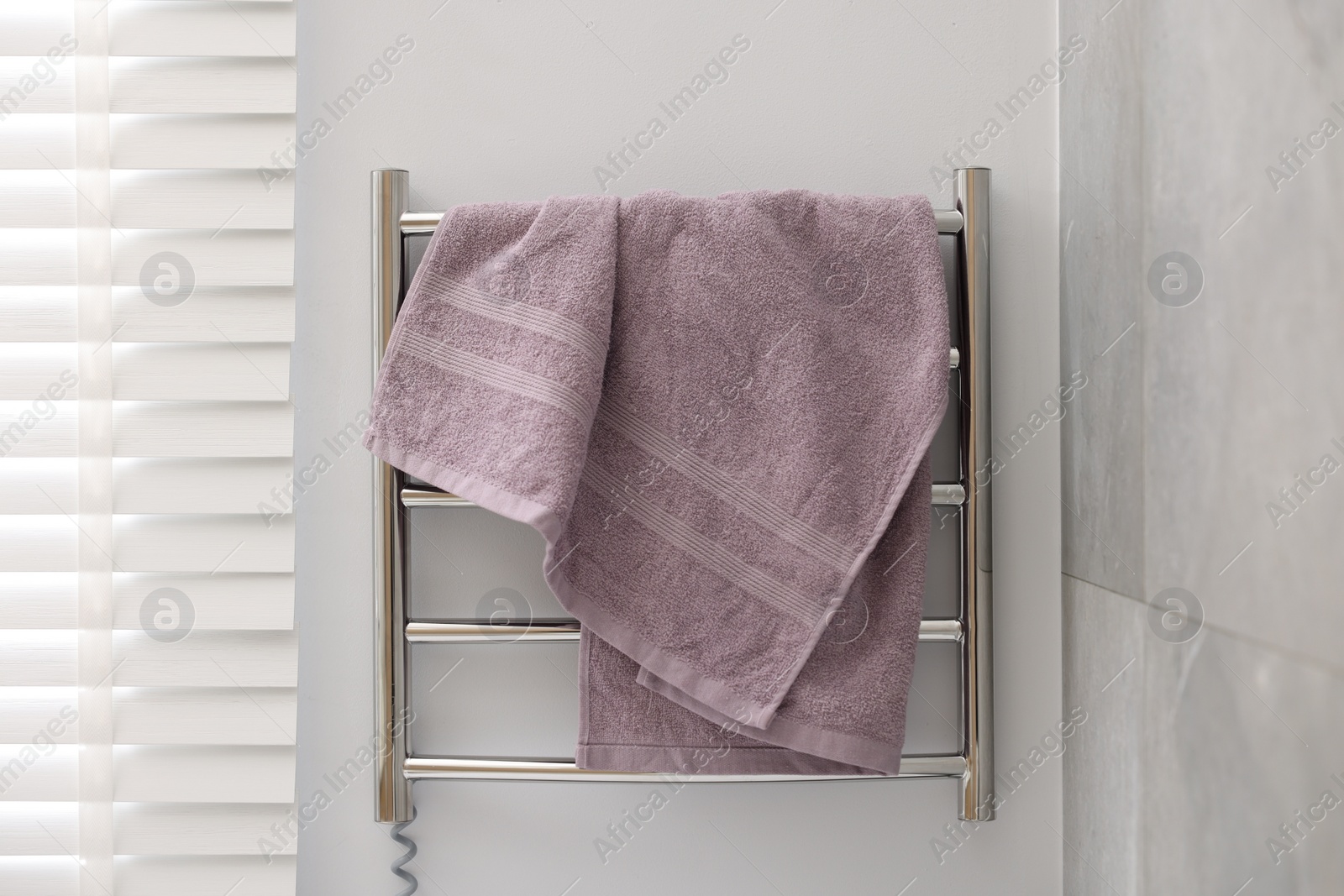 Photo of Clean terry towel on heated rail indoors