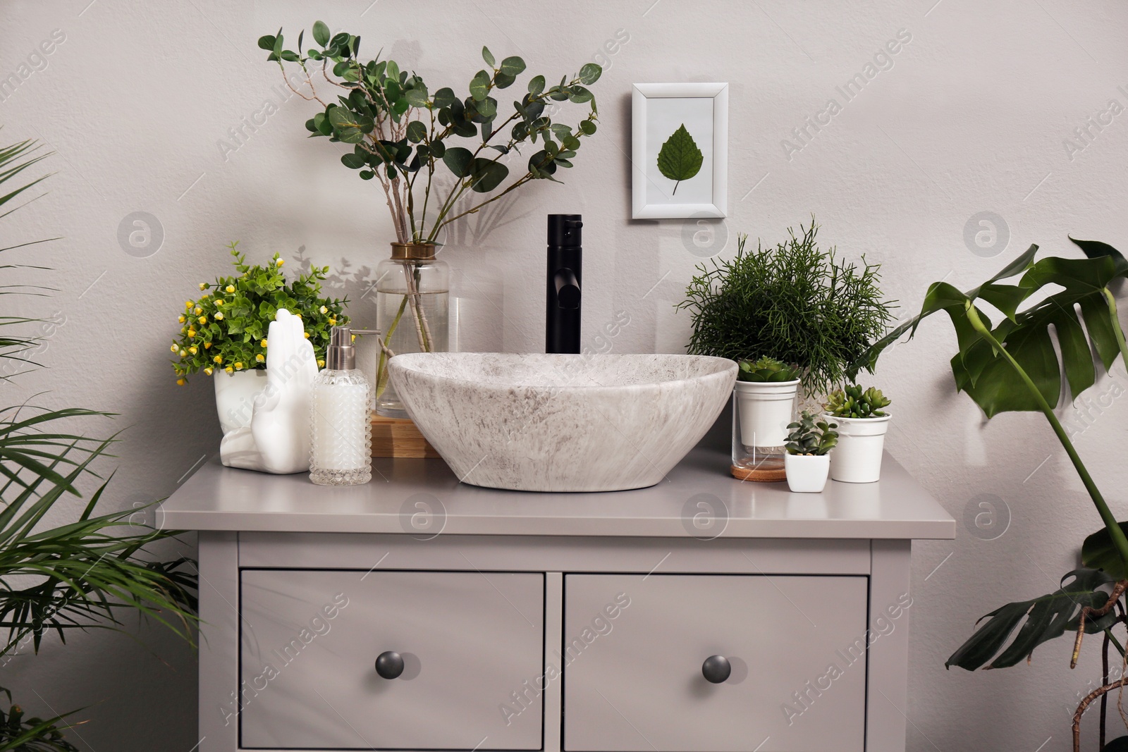 Photo of Stylish sink and beautiful green houseplants in bathroom. Interior design