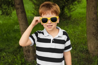 Photo of Cute little boy with sunglasses in park