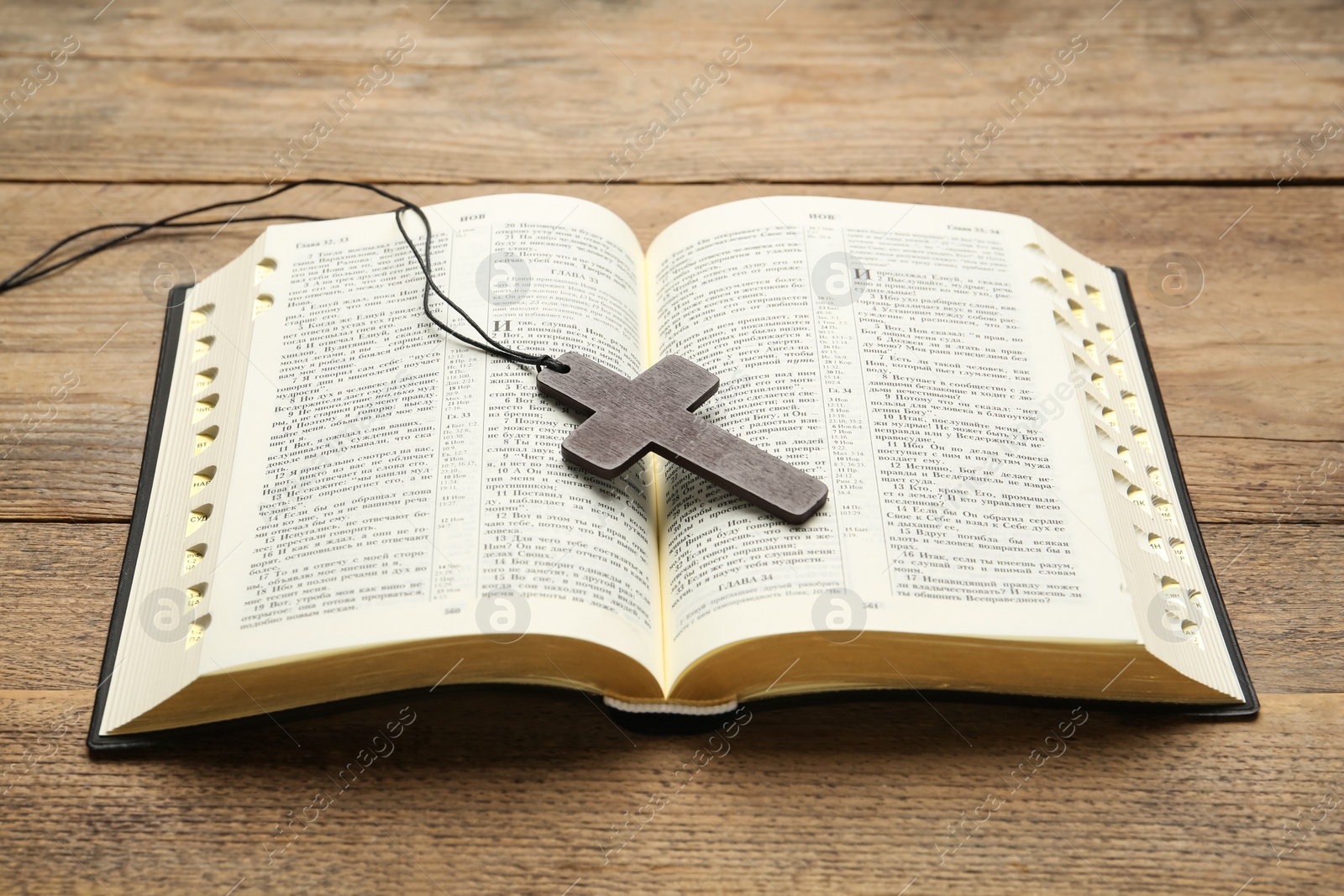 Photo of MYKOLAIV, UKRAINE - DECEMBER 20, 2021: Christian cross and Bible on wooden table