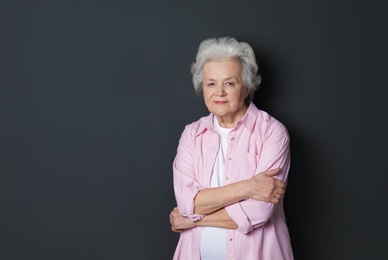 Portrait of mature woman on black background. Space for text