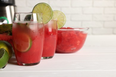 Photo of Tasty watermelon drink with lime and ingredients on white table, space for text