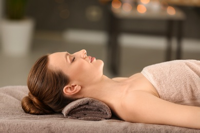 Photo of Beautiful young woman relaxing in spa salon