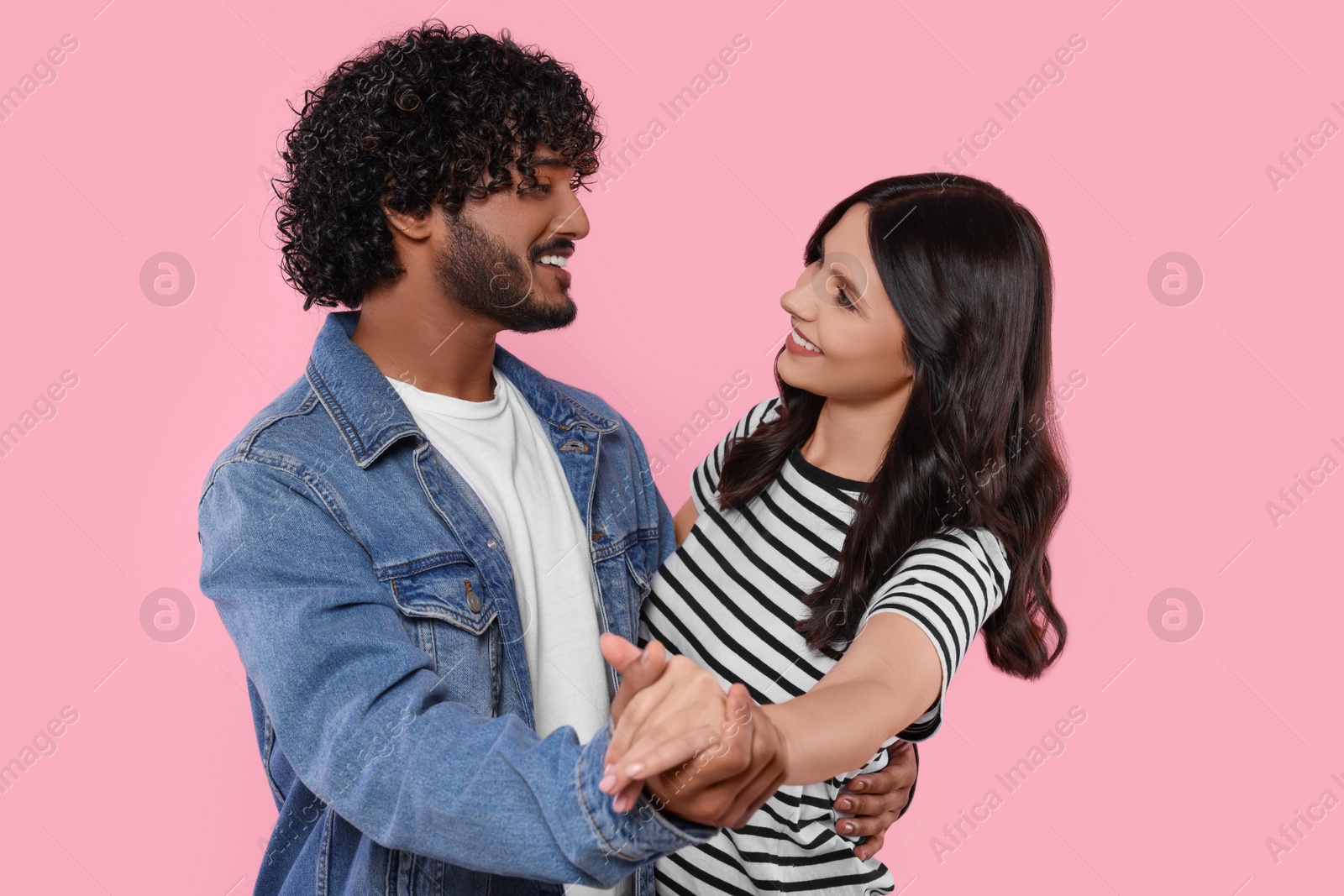 Photo of International dating. Happy couple dancing on pink background