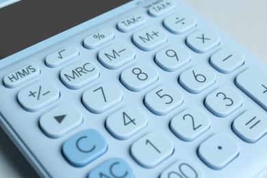 Closeup view of white calculator on light background