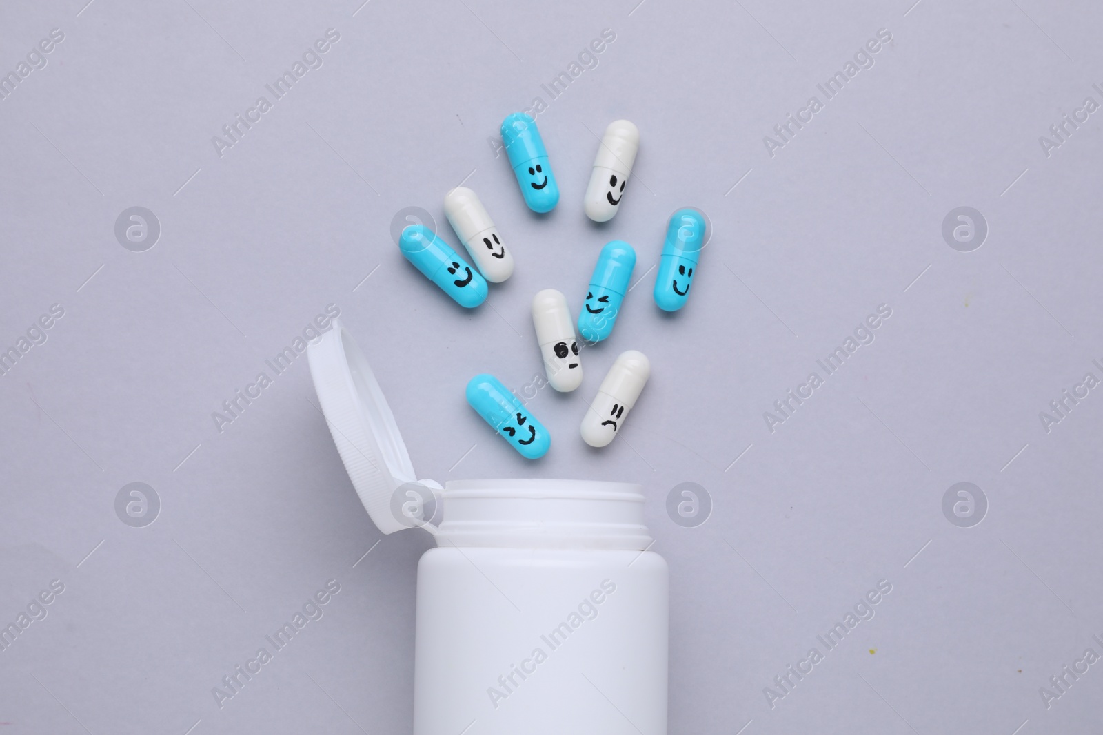 Photo of Antidepressants and medical bottle on grey background, flat lay