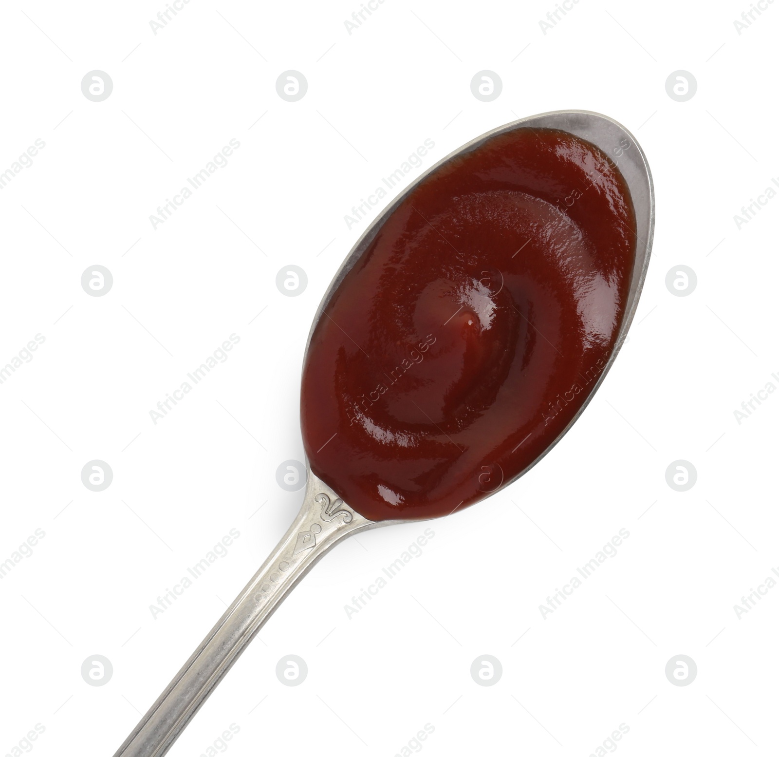 Photo of Tasty barbecue sauce in spoon isolated on white, top view