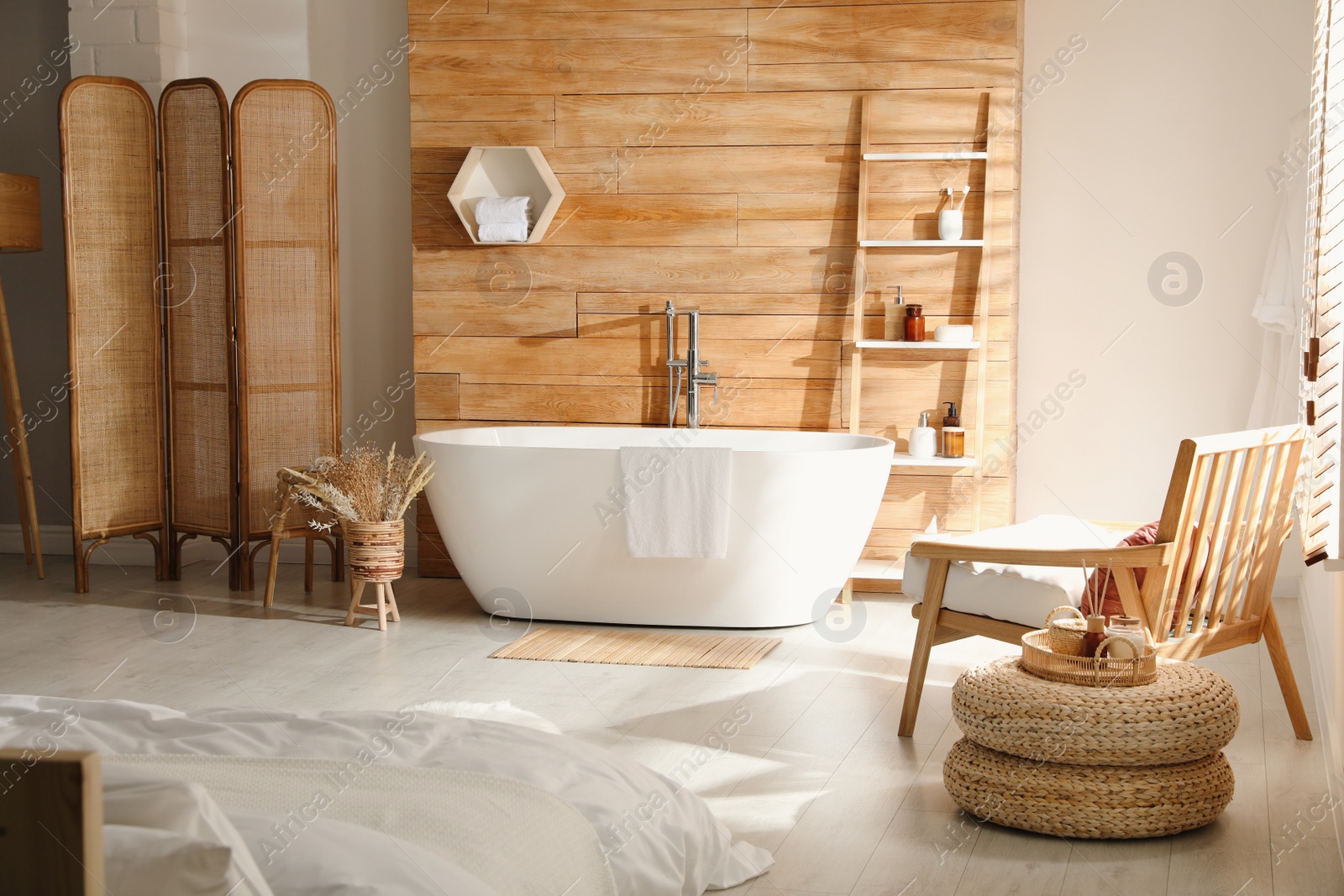 Photo of Stylish apartment interior with white bathtub and bed