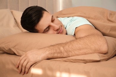 Man sleeping in bed with brown linens at home