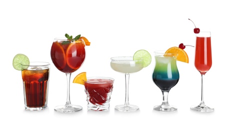 Glasses of traditional alcoholic cocktails on white background