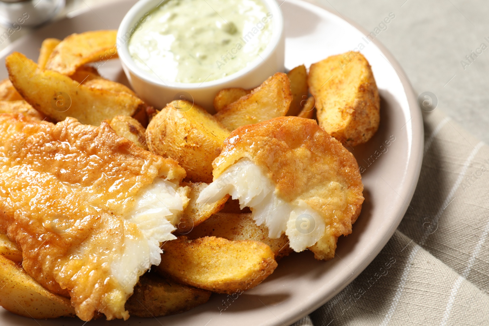 Photo of Plate with British Traditional Fish and potato chips on grey background, closeup