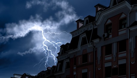 Dark cloudy sky with lightning over building. Stormy weather