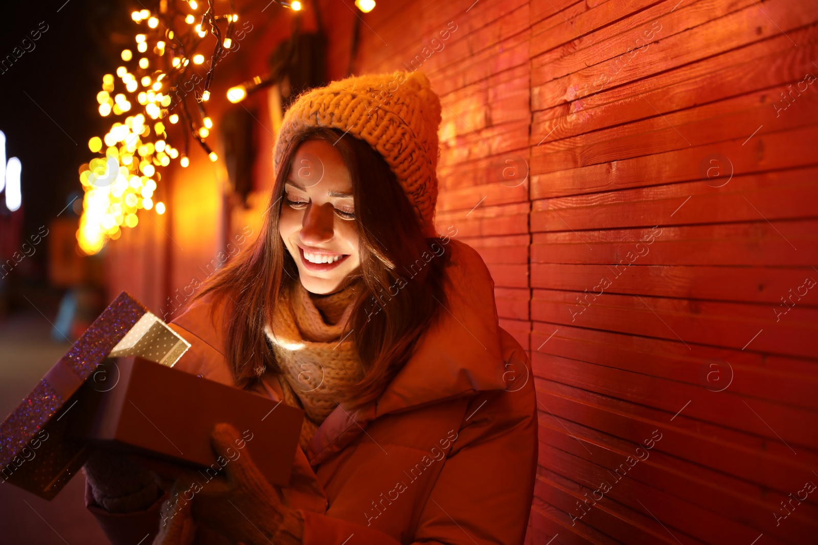 Photo of Happy woman with gift box at Christmas fair