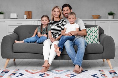 Portrait of happy family with children on sofa at home