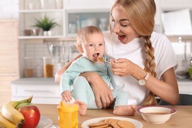 Photo of Woman feeding her child in kitchen. Healthy baby food