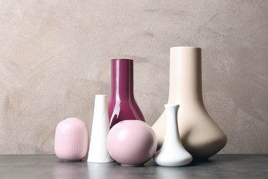 Stylish ceramic vases on grey stone table