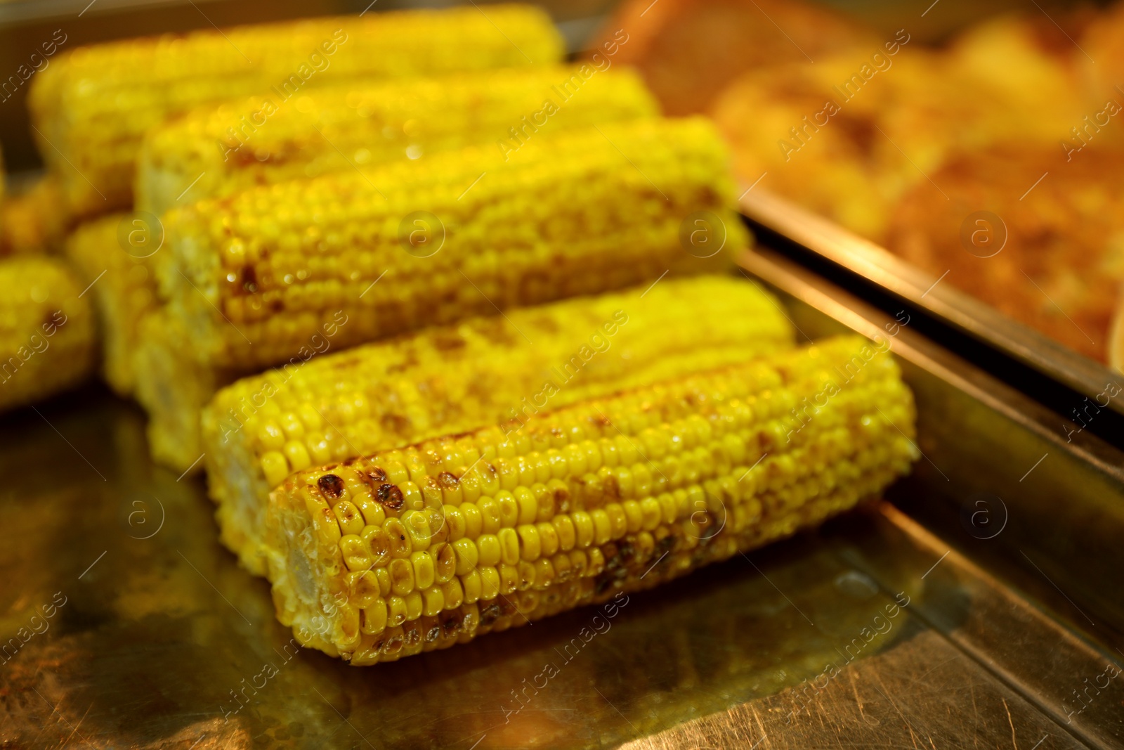 Photo of Delicious grilled corn cobs on table. Street food