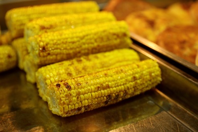 Photo of Delicious grilled corn cobs on table. Street food