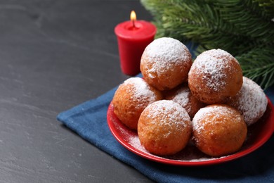Photo of Delicious sweet buns, fir tree branches and burning candle on dark gray table, space for text