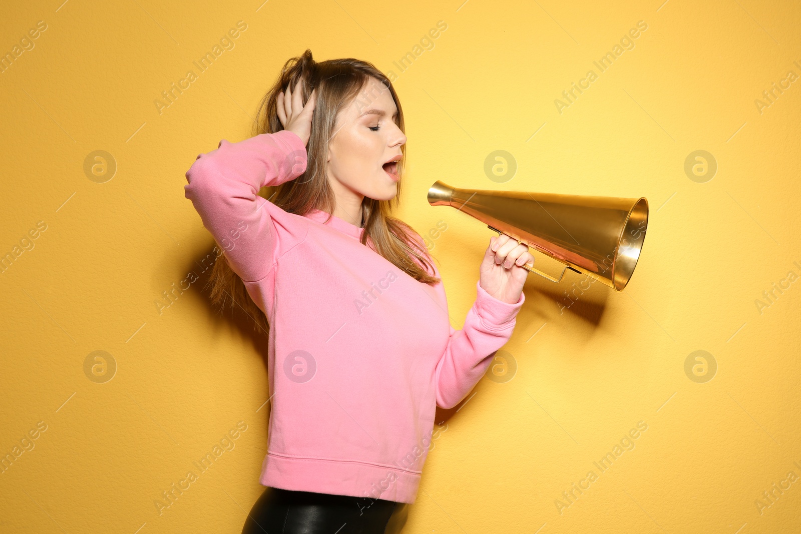 Photo of Young woman with megaphone on color background