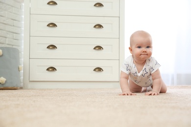 Photo of Cute little baby crawling on carpet indoors, space for text