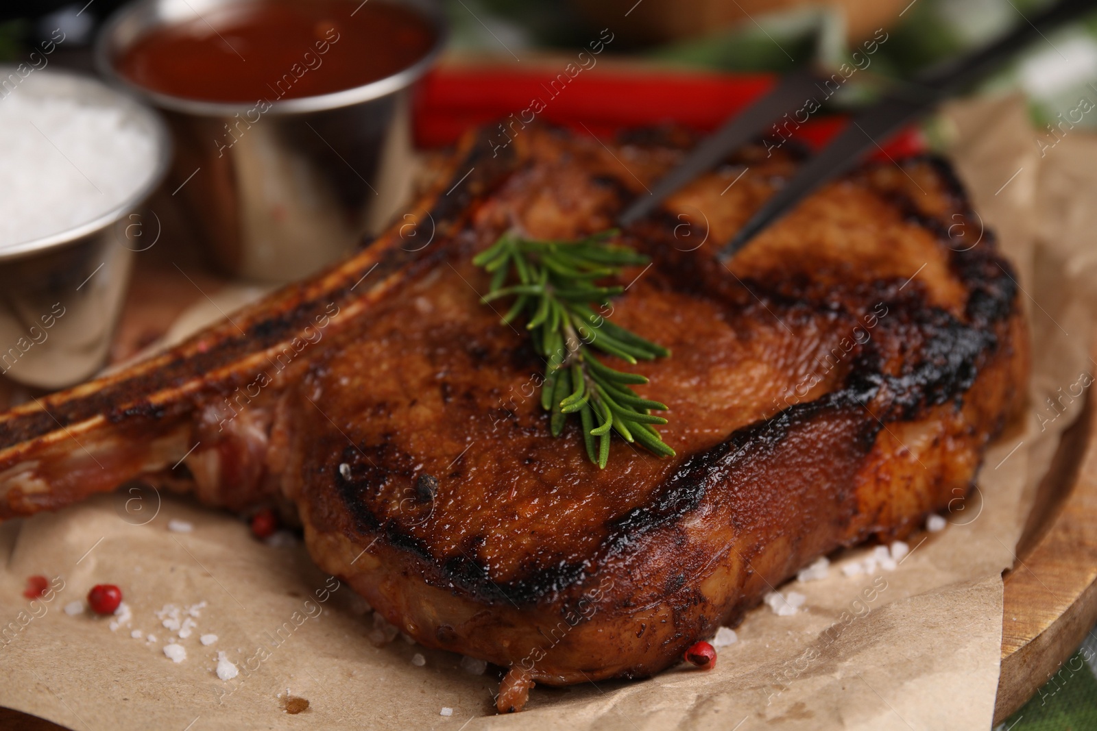 Photo of Tasty marinated meat, rosemary and spices on parchment, closeup