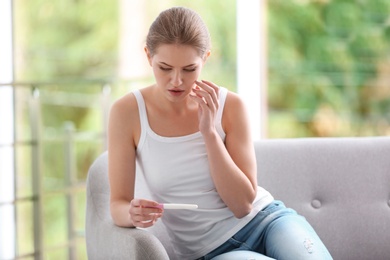 Young woman with pregnancy test at home. Gynecology