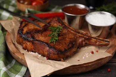 Photo of Tasty marinated meat, rosemary and spices on wooden table, closeup