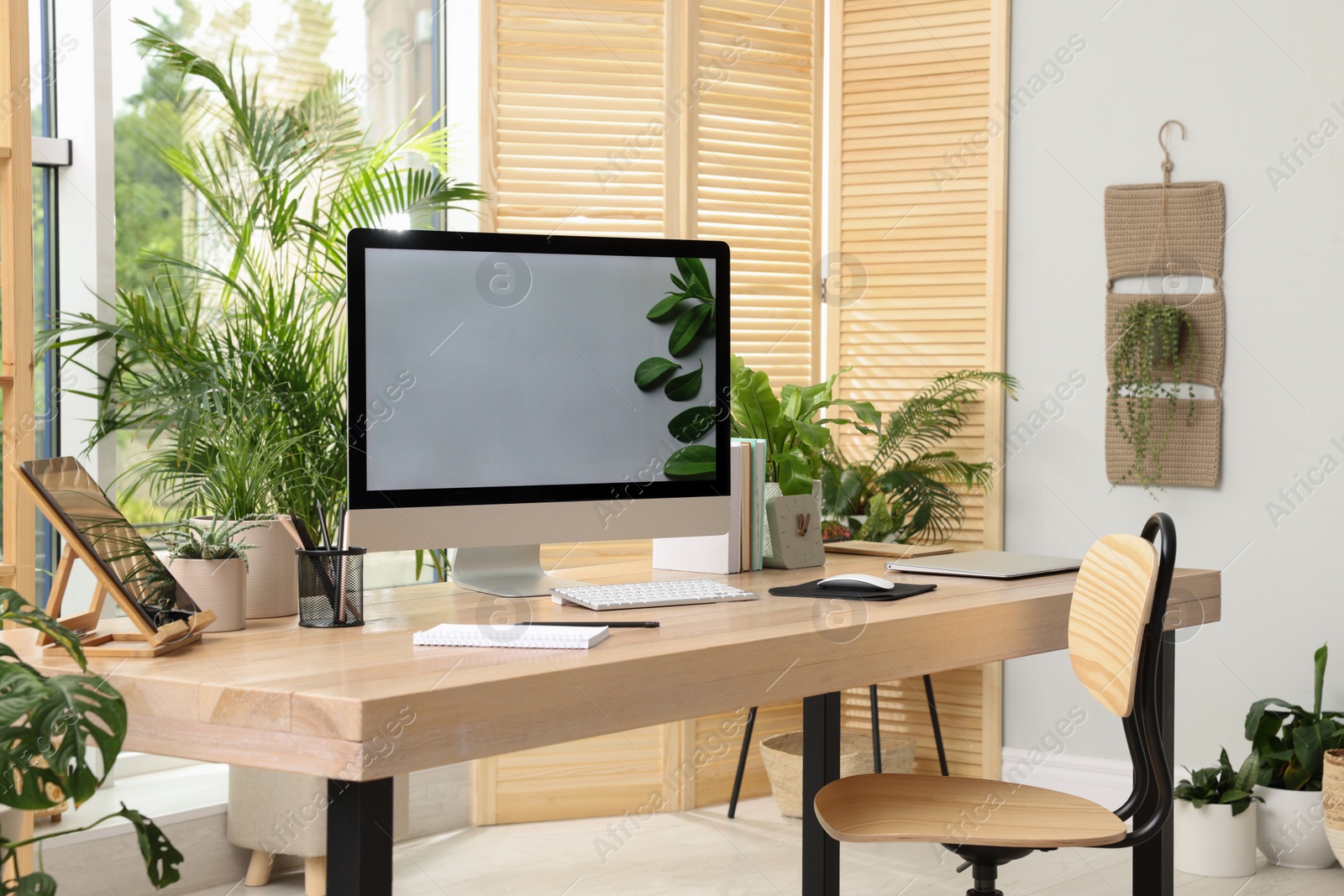 Photo of Comfortable workplace with computer in light room. Interior design