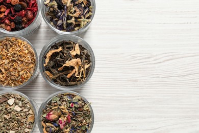 Photo of Flat lay composition with different dry teas on white wooden table. Space for text